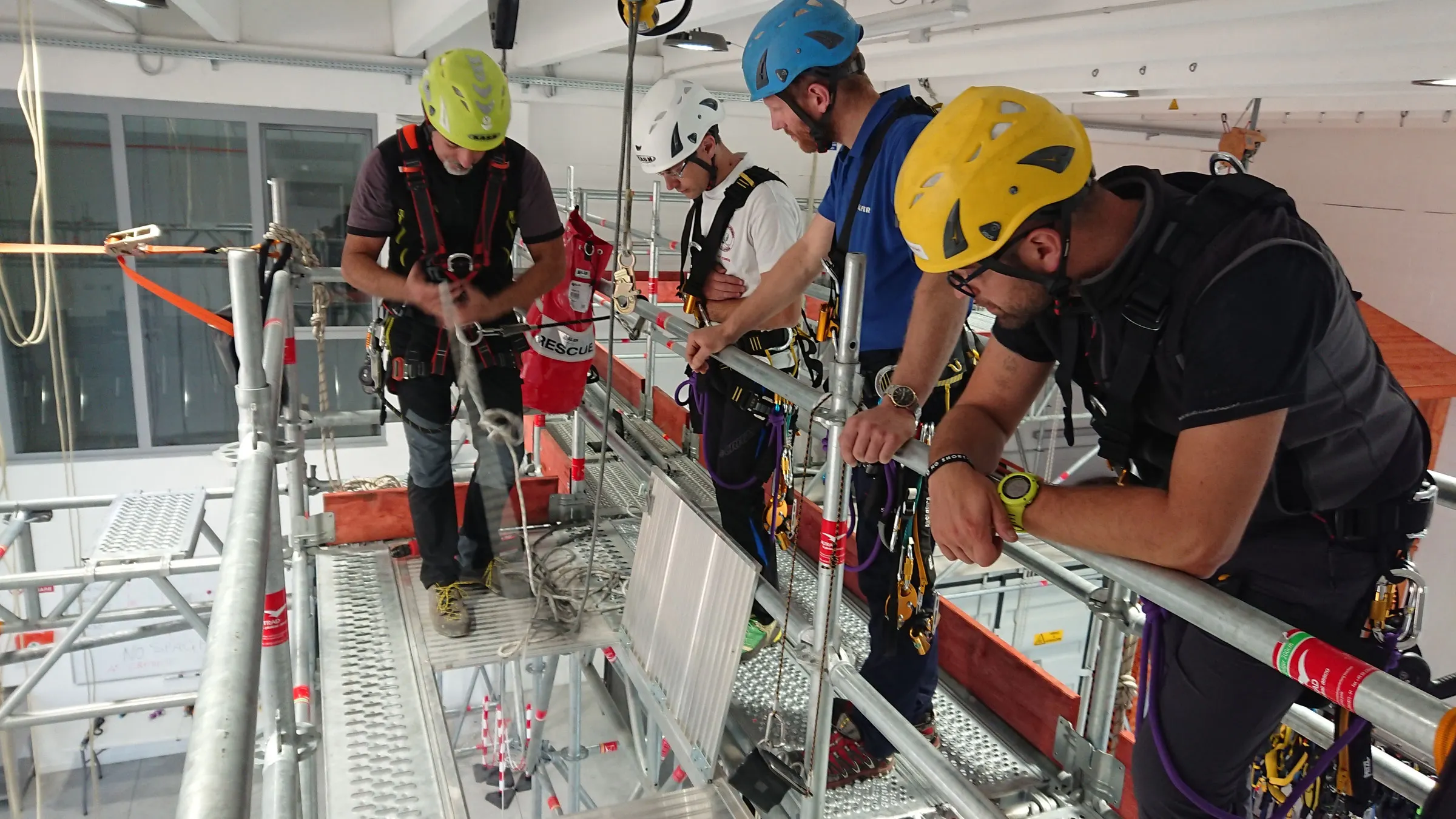 Partecipanti con casco e imbracatura nella palestra tecnica Vertika